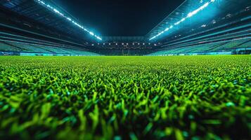 The soccer field is illuminated by vibrant lights, highlighting the lush green grass and empty stands photo
