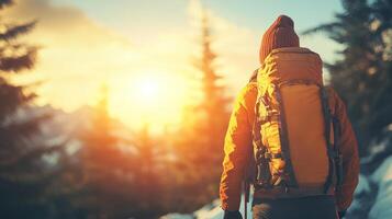 A hiker stands with a backpack, enjoying the breathtaking sunrise in a serene mountain setting photo
