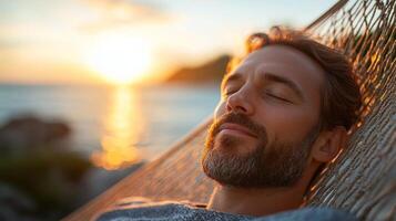 A man enjoys a peaceful moment in a hammock as the sun sets over the ocean, creating a tranquil atmosphere photo