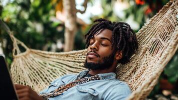A man lounges in a hammock, absorbed in reading while enjoying the serene atmosphere outdoors photo