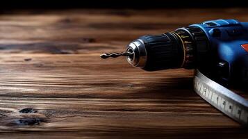 A power drill rests on a wooden surface next to a measuring tape, ready for home improvement projects photo