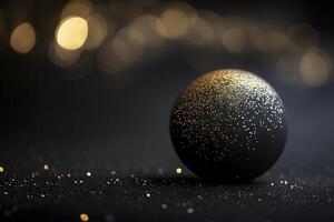 A shimmering black sphere with golden sparkles on a dark surface during a festive celebration atmosphere at night photo