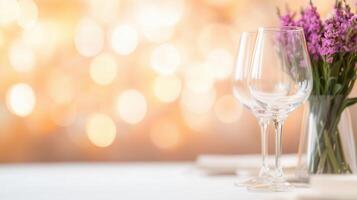 A table with two wine glasses and a vase of flowers photo