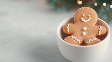 Xmas Gingerbread man cookie with white icing in a ceramic bowl on a light surface. Christmas tree branch with lights in the blurred background. Holiday baking and festive treat concept photo