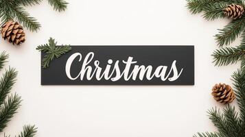 Minimalist Christmas Sign with White Cursive Text on Black Paper Surrounded by Pine Branches and Pinecones for Winter Holiday Decor photo