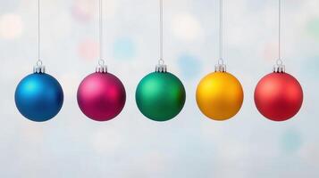 Colorful Christmas Ornaments Hanging in a Line Against a Soft Focus Background Representing Holiday Cheer and Festive Decoration with Vibrant Red, Blue, Green, Pink, and Yellow Baubles photo