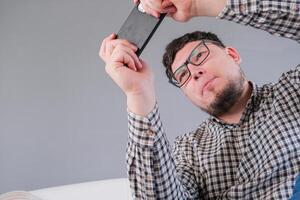 man sitting on the bed using smartphone to play games photo