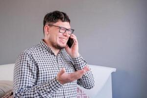 man sitting on the bed using smartphone having a call photo