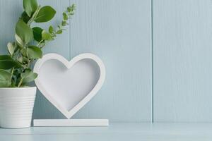 Photo frame of heart shape for mockup design on light table background.