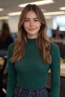A confident young female entrepreneur smiling warmly while looking directly at the camera in a modern workspace. photo