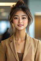 A close-up portrait of a confident young woman in business attire, smiling softly while looking straight at the camera. photo