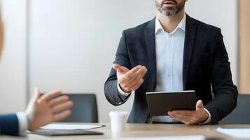 Business professional explaining key data from a digital tablet to team members in a contemporary meeting room photo