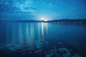 A full moon over the water at night photo