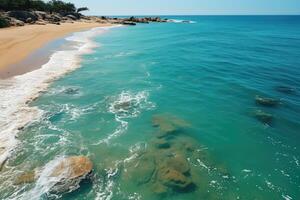 An aerial view of a beach with waves and rocks photo