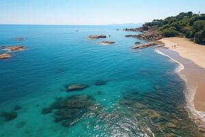 An aerial view of a beach with clear water and rocks photo