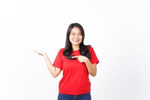 Smiling, Pointing and presenting product for ad on open hand palm Of Beautiful Asian Woman Wearing red shirt Isolated On White Background photo