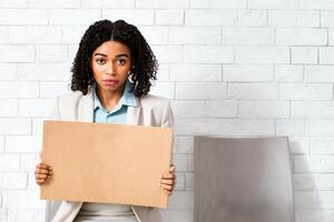 Young black lady with blank sign waiting for employment interview at office lobby, space for design. Panorama photo
