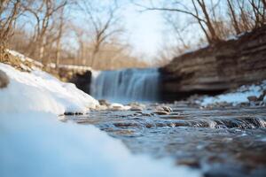 A waterfall in the winter with snow on the ground photo