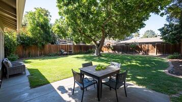 A backyard with a table and chairs in the grass photo