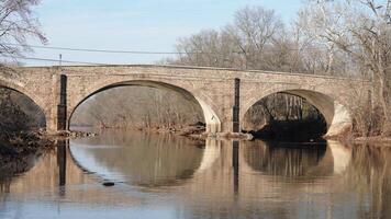 One old arched bridge cross above the river in the countryside of the USA photo