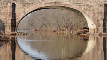 One old arched bridge cross above the river in the countryside of the USA photo
