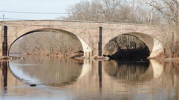 One old arched bridge cross above the river in the countryside of the USA photo