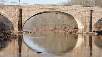 One old arched bridge cross above the river in the countryside of the USA photo