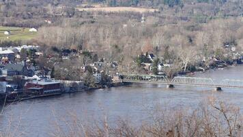One old iron bridge cross the Delaware river between two old town in autumn photo