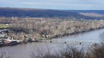 One old iron bridge cross the Delaware river between two old town in autumn photo