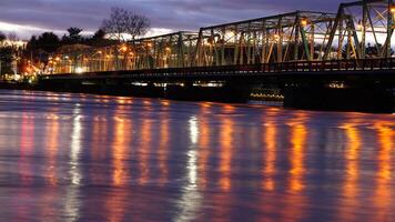 One old rion frames bridge view on the river with the sunset sky as background photo