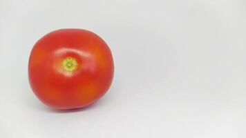 A Fresh Red Tomato Displayed on a Clean White Background, Ready for Cooking and Enjoyment photo