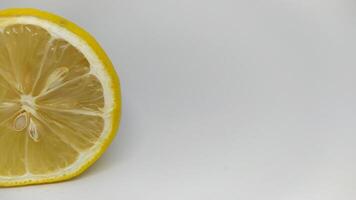 A Freshly Cut Lemon Slice Presented on a Light and Bright Background for Culinary Use photo