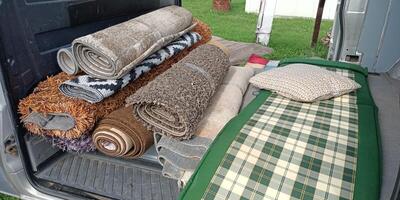 Explore a diverse selection of beautifully rolled rugs and stylish mats conveniently stored in a van photo