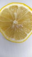 A Freshly Cut Lemon Half Displaying Its Visible Seeds and Exuding a Juicy Texture photo