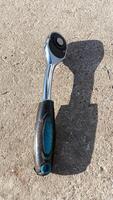 A detailed closeup view of a shiny Chrome Socket Wrench resting on a Concrete Surface photo