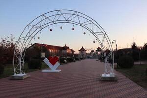 Charming Decorative Archway Set in a Beautiful Scenic Park During a Lovely Sunset photo