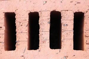 A Textured Brick Wall featuring Vertical Openings which creates an interesting visual effect photo