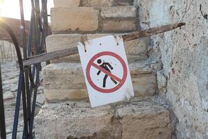 There is a No Walking Sign installed on the rustic, uneven stone steps for safety purposes photo