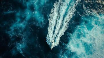 An aerial view of a boat traveling through the ocean photo