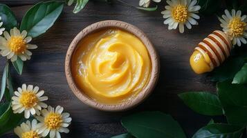 A bowl of honey and flowers on a wooden table photo