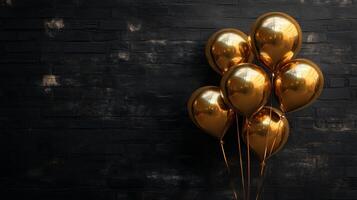 Gold balloons on a black wall background photo