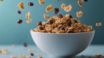 White bowl of bran flakes with raisins falling into it photo
