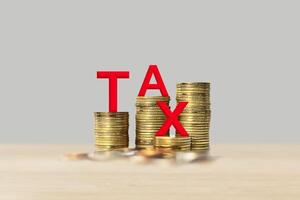 Red tax from 3D volumetric letters with stacked coins. Visualization of tax charging and payment in business photo