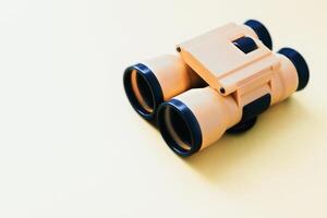 a pair of binoculars on a yellow background photo