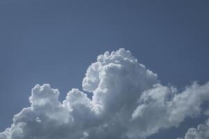 a plane flying in the sky with some clouds photo