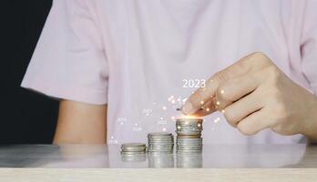 a person is holding a stack of coins with the year 2023 on it photo