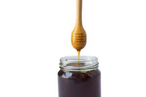 honey in a jar with a wooden spoon photo