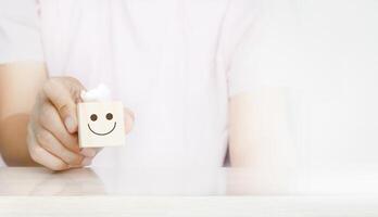 a person holding a smiley face toy in their hand photo