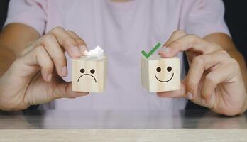 Customer review, two people holding wooden blocks with smiley faces on them photo