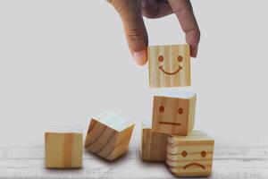 a hand holding wooden blocks with smiley faces on them photo